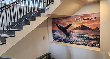 蘭海龜山島漁村文化館｜樓梯間情境牆 配合樓梯動線的大面積牆面輸出施作，視覺延伸串聯上下樓層
