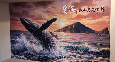 蘭海龜山島漁村文化館｜主視覺鯨躍大圖 梯廳整面鯨躍主視覺高解析輸出裱貼，色彩飽和、無接縫平整